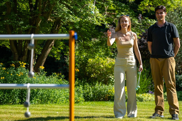 Ein Paar spielt Leitergolf im Garten