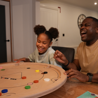 Zwei Spieler lachen gemeinsam bei einer Partie Carrooka Natural am Tisch