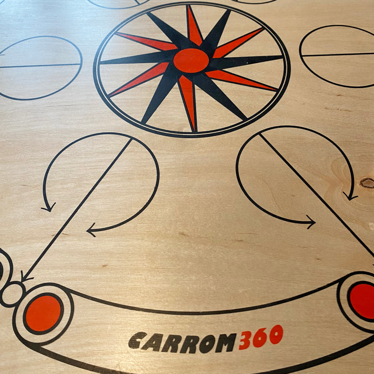Nahaufnahme des Siebdruckdesigns des Carrooka Carrom360 Bretts mit Stern und Logo