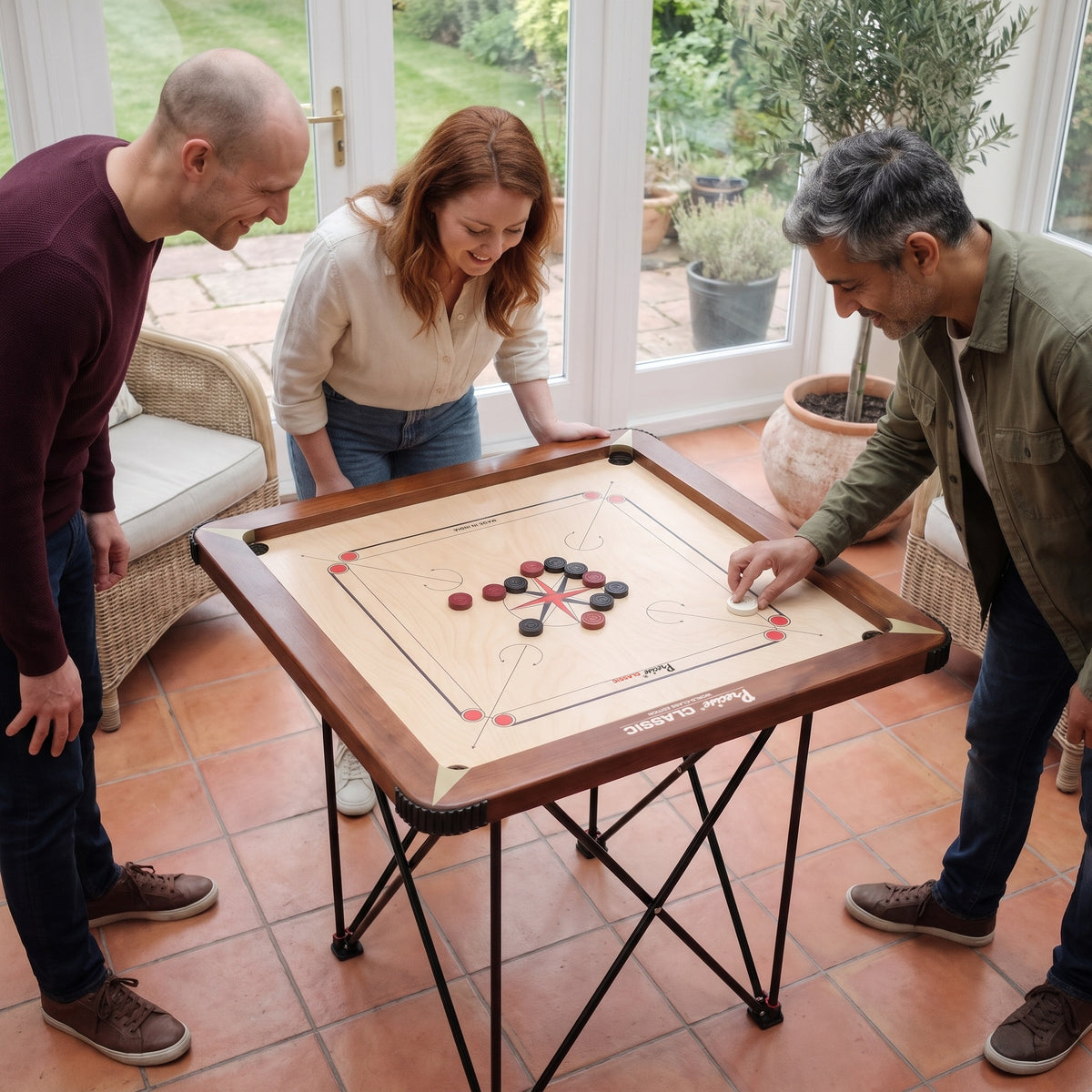 Spieler schnippt den Striker auf dem Precise Carrom Brett World-Class Edition, Ansicht schräg von oben